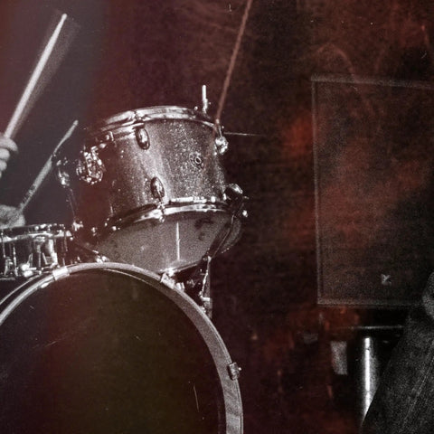 Close-up of drum set with dark stage lighting, showcasing live performance energy beside 50 Watt Intelligent Guitar Combo Amp With Amp Intelligence, Prompt Photo And Audio Tone Creation, USB Recording, Selectable Wattage, And Fully Customizable Signal Chains In The Reactor App For Gig Ready Flexibility.