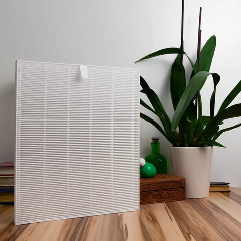 Replacement HEPA Filter A 115115 for Winix PlasmaWave Series next to potted plant on wooden table