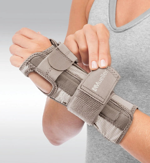 Woman wearing taupe Reversible Wrist Stabilizer With Splint For Men And Women, Adjustable Pain Relief Wrist Brace For Carpal Tunnel Tendinitis And Arthritis on left wrist.
