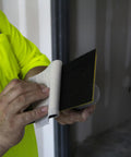 Person changing Quick Change Hook And Loop Pro Grade Drywall Sandpaper 80 And 100 Grit Sheets in construction setting
