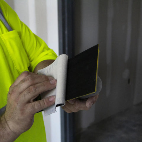 Person changing Quick Change Hook And Loop Pro Grade Drywall Sandpaper 80 And 100 Grit Sheets in construction setting