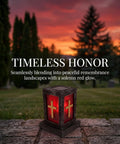 Memorial lantern with red glow and cross design in a sunset graveyard landscape