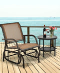 Cozy Brown Swing Glider Chair With Sturdy Metal Frame by the sea on a wooden deck with a side table and wine