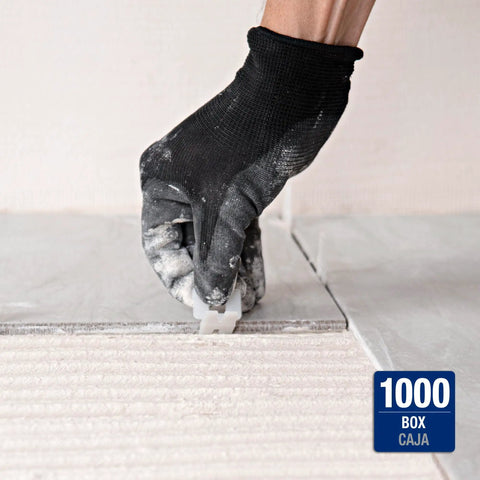 Gloved hand using LASH Tile Leveling System Part A Clips For One Sixteenth Inch Grout 1000 Pack to align floor tiles