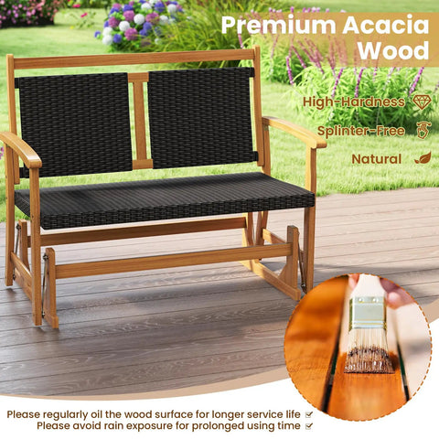 Two Person Wooden Outdoor Glider Bench With Acacia Wood Armrests And Wicker Back And Seat Rocking Patio Loveseat shown on patio
