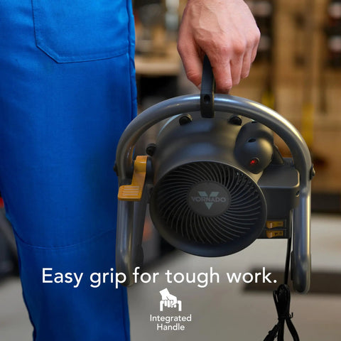 Person holding Velocity Tuned Heat Garage Heater With Fan And Tilt Head, showcasing integrated handle, black color.