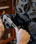Mechanic using 11 inch automotive wrench with big jaw capacity and slim head on engine, smooth jaws protecting fittings.