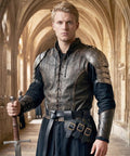 Person wearing Medieval Viking Sword Frog Holster With Adjustable Belt Straps and armor in a stone corridor