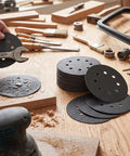 Top Tier 200 Pack Of 5 Inch Silicon Carbide Hook Loop Sanding Discs With 8 Holes For Power Tools on a workbench with tools.