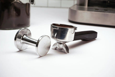 Pro Grade Dual Sided Espresso Tamper With Durable Aluminum Alloy Construction beside espresso portafilter on counter
