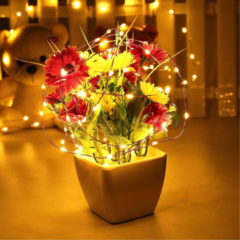 Fairy String Lights 33 Ft 100 LEDs Copper Wire Plug In Indoor Outdoor With 8 Lighting Modes And Memory Function For Bedroom Parties Weddings Christmas Decor wrapped around flower arrangement in vase