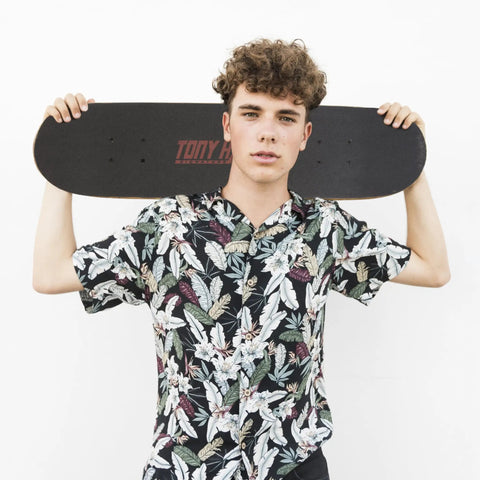 Person holding a 31 Inch Pro Trucks Skateboard With Full Grip Tape And 9 Ply Maple Deck For Easy Cruising And All Skill Levels Signature Series Longboard Style Cruiser Built For Beginners To Pros across shoulders