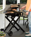 Man grilling on outdoor patio with stainless steel 3 piece BBQ grilling tool set with spatula fork and tongs plus bonus grill glove for outdoor grillin mastery this essential cookout kit makes a killer gift for men dads and real grill lovers