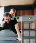 Man exercising with child on his back in a modern home, interactive screen displaying smart technology options for home control.