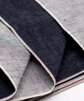 Close-up of 16oz Heavyweight Selvedge Denim Fabric 100 Percent Cotton Raw Indigo Shuttle Loom Woven 35 Inch showing edges.
