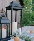 Large Outdoor Solar Powered Lantern With Open Frame No Glass Black Metal 19 Inch Tall Dusk To Dawn Timer Flickering LED Candle Lantern For Porch Patio Garden Rustic Farmhouse Vibe on outdoor table