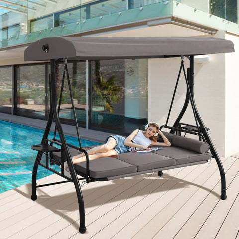 Woman relaxing on a Three Seat Patio Swing With Adjustable Canopy And Stand Heavy Duty Outdoor Porch Glider Bench With Cushions Pillows And Cup Holder For Backyard Garden Lawn Poolside Gray by a poolside.