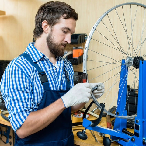 Mechanic using Folding Hex Key Set With Metric And SAE Allen Wrenches, Heat Treated S2 Finish on bicycle wheel in workshop.