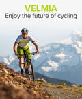 Cyclist on mountain trail wearing helmet and biking gear with mountains in the background.