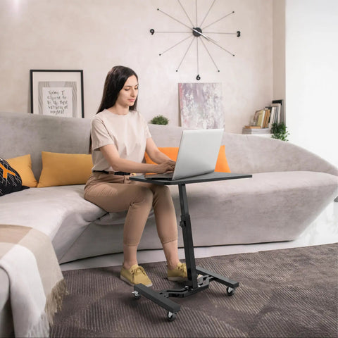 Woman using Height Adjustable Laptop Rolling Cart for Ergonomic Workstation Use, Mobile Desk from 28 Inches to 33 Inches, Black Finish.