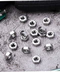 Heavy Duty Stainless Steel Hex Nuts Rock Solid Hardware Fasteners For Home Repairs And Industrial Projects Polished Steel Parts on gray surface.