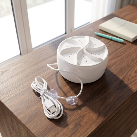 Compact Travel Mini Ultrasonic Turbo Washer With Ultra Quiet Tech Fits Snugly In Suitcases For Dorms And Road Trips on a wooden table.