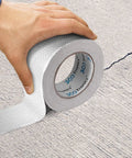 Person applying Heavy Duty Waterproof Butyl Sealing Tape With Aluminum Foil Backing For RV Roofs And Gutters on a cracked surface