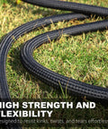 Close-up of black braided garden hose coiled on grass.
