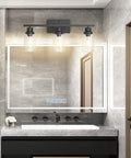 Matte Black 3 Light Vanity Light Fixtures With Clear Glass Shade in modern bathroom setting, wall mount above mirror