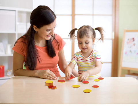 Mother and child engaging with Super Awesome Red And Yellow Counting Blocks Pack Of 200 at a table, promoting hands-on learning.