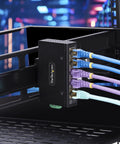 Unmanaged 5 Port Industrial Gigabit Ethernet Switch with multiple cables connected, mounted on a DIN rail in a server rack.