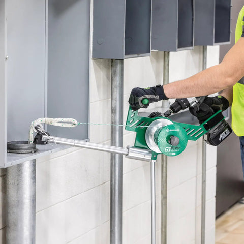 Greenlee G1 Versi-Tugger Handheld Cable Puller in use, pulling wire through conduit with ergonomic handling.