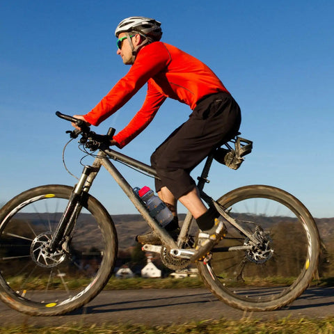 Cyclist on mountain bike with Front Fork Mounted Water Bottle Cage And Cargo Rack For Bikes - Durable Bike Front Rack
