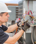 Technician installing Air Conditioner Capacitor Replacement 70uF 370/440V Round in HVAC system outdoors.