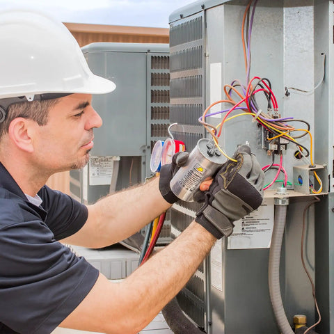 Technician installing Air Conditioner Capacitor Replacement 70uF 370/440V Round in HVAC system outdoors.