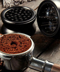Pro Level 58mm Coffee Powder Distributor And Espresso Stirrer Tool featuring adjustable height dial on wooden table with coffee grounds.