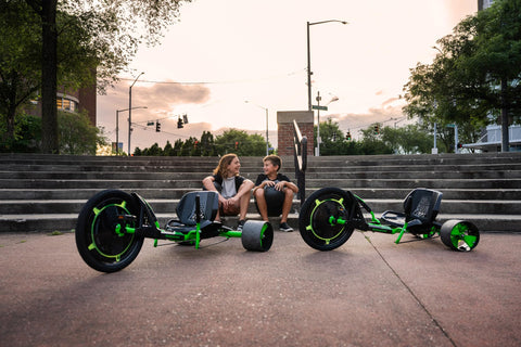 Kids sitting with Green Machine 20 Inch Drift Trike for Kids 8 and Up with Dual Stick Steering, Adjustable Seat, Durable Steel Frame.