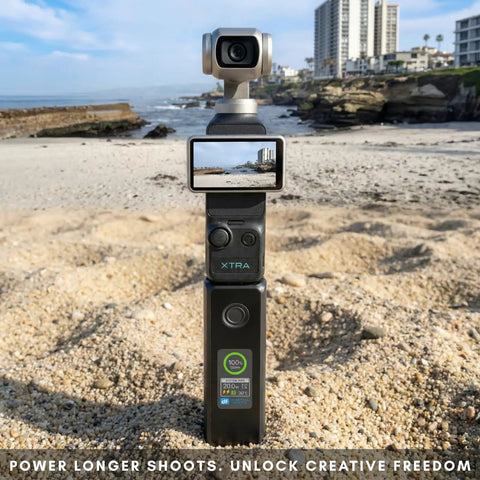 Pocket 4 By 3 Battery Grip With 20W Fast Charging For DJI Pocket 3 Xtra Muse shown on sandy beach with LCD display screen.