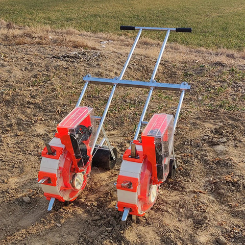 Hand Push Garden Seeder With Fertilizer Applicator on soil, double row design, see-through hopper visible
