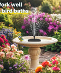Solar Pond Fountain Pump 5.5W With Double Layer Nozzles installed in a bird bath surrounded by blooming flowers