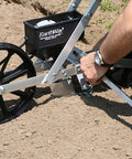 Person using Pro Grade Precision Garden Seeder With 7 Seed Plates For Home Gardeners on prepared soil