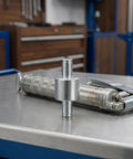 Heavy Duty Steel Hydraulic Pallet Jack Handle Roller With Gleaming Polish positioned on a work surface with hydraulic pump.