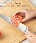 Slicing tomato with 14 Piece Full Tang Kitchen Knife Set With Wood Block Sharpener, high carbon stainless steel blade on cutting board