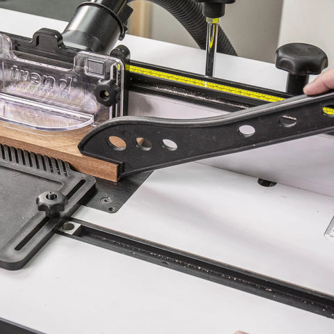 Rock Solid Free Standing Router Table With Heavy Duty Steel Base And Spacious 24 By 16 Inch Laminated Top Built Like A Tank For Precision Cabinet Work Featuring Smooth Aluminum Fence System, close-up of aluminum fence and wood piece.