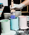 Painter using Two Pack Wood Handle Paint Brush Set Featuring 3 Inch Flat And 2.5 Inch Angled Sash Brushes with blue paint