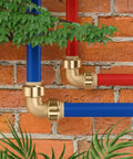 Three Quarter Inch Push Fit Elbow Fittings 12 Pack No Tools Needed Easy Quick Connect For Copper PEX CPVC Brass Plumbing Pipes 90 Degree Push To Connect Elbows Lead Free Brass Durable Home Repair Fittings connected to red and blue pipes against brick wall.