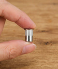 Close-up of a hand holding one of the 50 Pcs Stainless Steel Threaded Insert Nuts M6 Flat Head Rivnuts Kit for secure metal fastening.