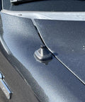 Close-up of Antenna Delete Cap For Ford F-150, SVT Raptor, And F-150 Lightning EV on truck hood with textured black finish