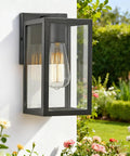 Outdoor Wall Lantern For Porch And Entryway Weather Resistant Exterior Mount Lighting Fixture Black Four Pack Durable Aluminum Sconce Lamp For Garage Patio And Hallway shown installed on a white wall with garden background