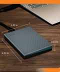 2TB Portable External Hard Drive With USB C And USB A For Windows Mac Chromebook Consoles And Mobile Devices Plug And Play Convenience next to laptop